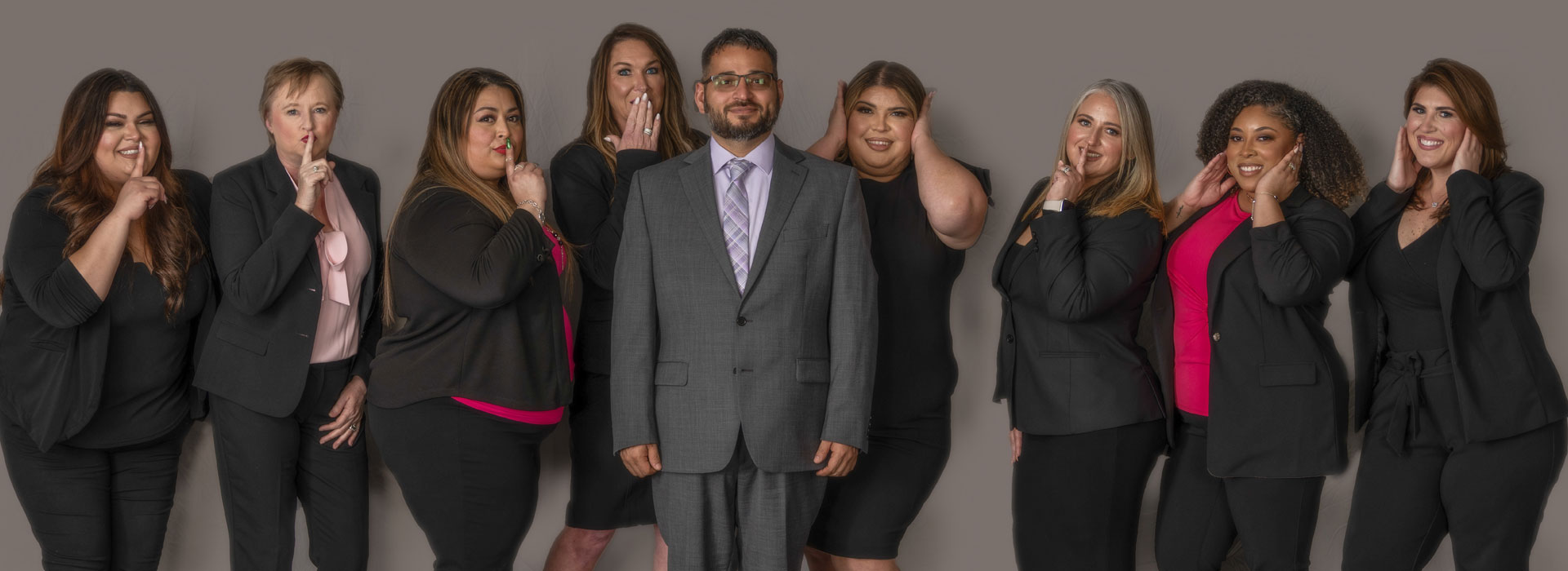 team in business attire posing playfully with “see no evil, hear no evil, speak no evil” gestures