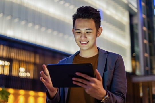 a man looking at a tablet device